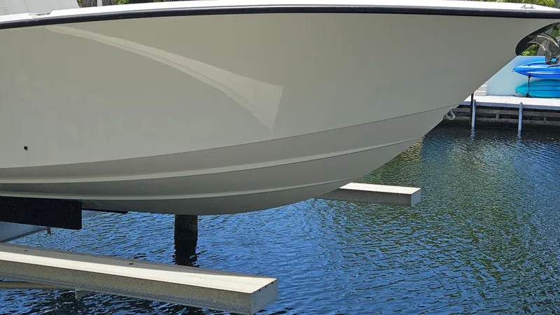  Yacht Photos Pics 2023 SeaVee 370z boat on lift above water, showcasing sleek hull design.