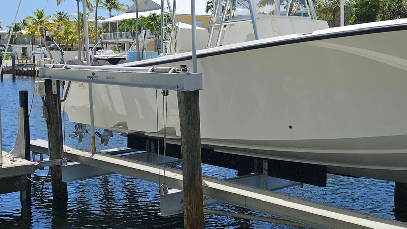  Yacht Photos Pics 2023 SeaVee 370z boat on a lift, docked by a waterfront.