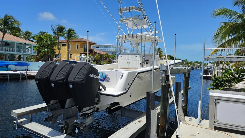  Yacht Photos Pics 2023 SeaVee 370z boat with triple Mercury engines docked in a scenic waterfront setting.
