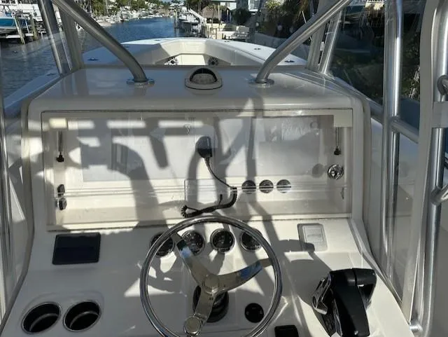  Yacht Photos Pics 2023 SeaVee 370z boat helm with steering wheel and controls, docked by a canal.