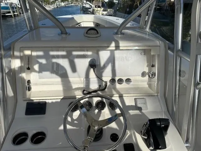  Yacht Photos Pics 2023 SeaVee 370z boat helm with steering wheel and control panel, docked by a canal.