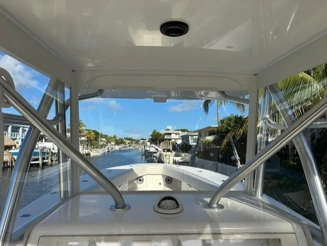  Yacht Photos Pics 2023 SeaVee 370z boat navigating a scenic canal with palm trees and waterfront homes.