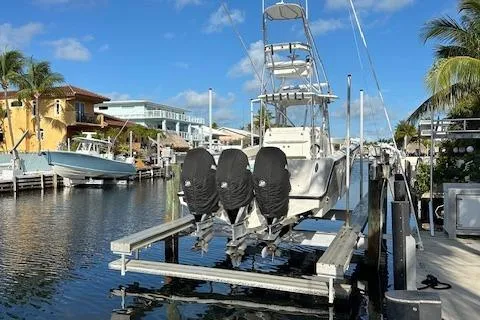  Yacht Photos Pics 2023 SeaVee 370z boat docked with triple engines, surrounded by palm trees and waterfront homes.