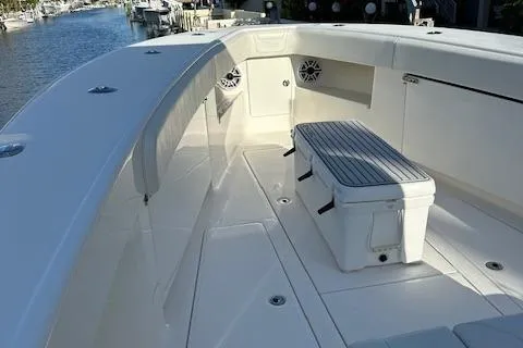  Yacht Photos Pics 2023 SeaVee 370z boat deck with seating and storage, docked by a serene waterway.