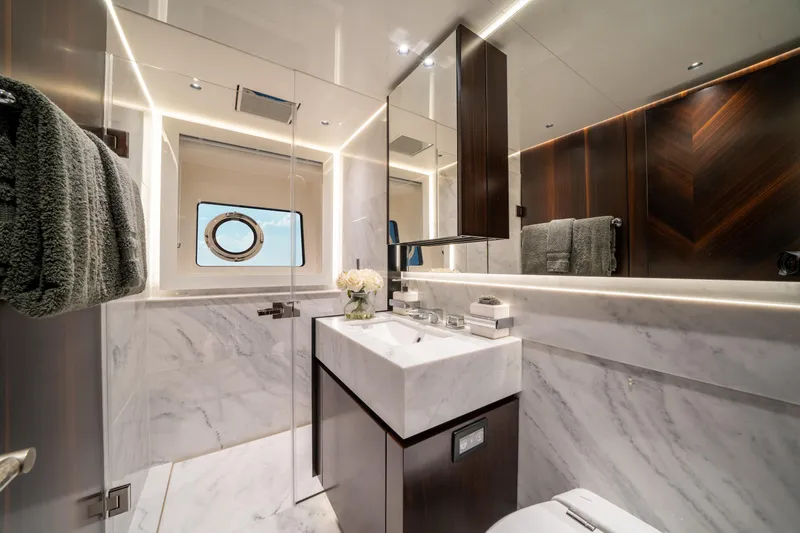 White Star Yacht Photos Pics Luxurious bathroom in 2023 Sunseeker 90 Ocean yacht with marble and wood accents.