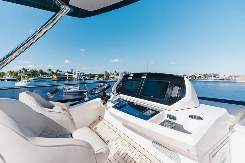 White Star Yacht Photos Pics 2023 Sunseeker 90 Ocean yacht helm with modern controls and scenic marina view.