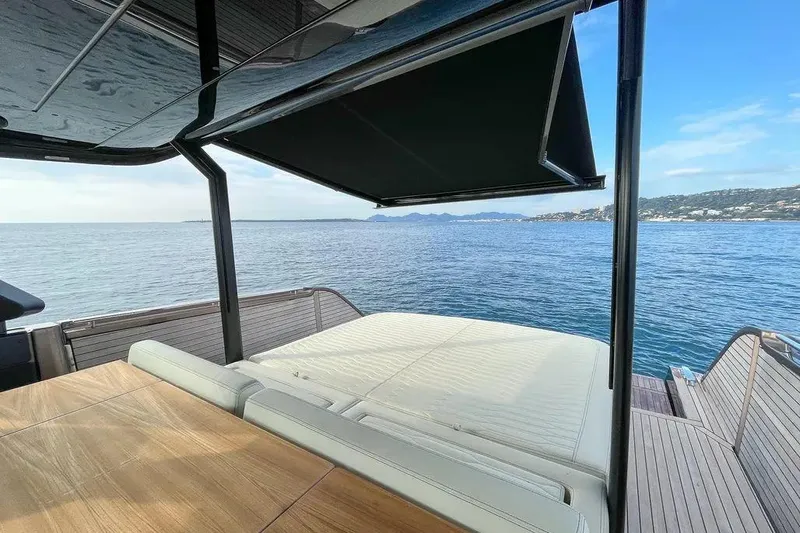  Yacht Photos Pics Cranchi A46 Luxury Tender 2021 yacht with sunbed and canopy, overlooking serene ocean view.
