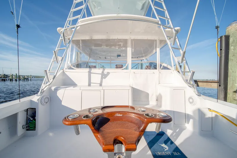 Urgent Sea Yacht Photos Pics 2003 Viking 45 Express yacht, spacious deck, fishing chair, clear sky, docked at marina.