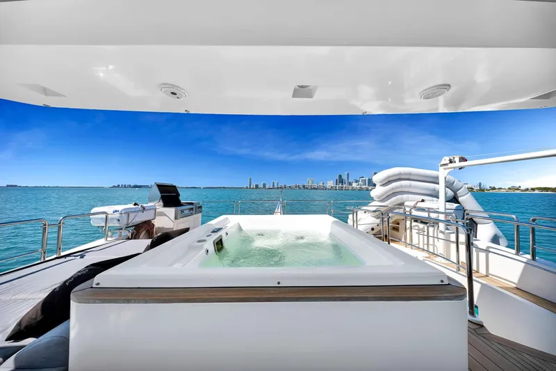 Babieca Yacht Photos Pics Luxurious 2005 Azimut 105 yacht with jacuzzi, ocean view, and city skyline in the background.