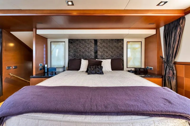 Babieca Yacht Photos Pics Luxurious bedroom interior on a 2005 Azimut 105 yacht, featuring elegant wood finishes.