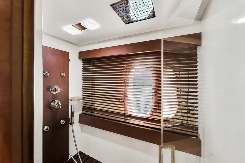 Babieca Yacht Photos Pics Luxurious shower area in 2005 Azimut 105 yacht with wooden accents and porthole window.