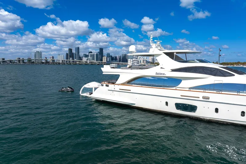 Babieca Yacht Photos Pics Luxury Azimut 105 yacht from 2005 on water, city skyline in background.