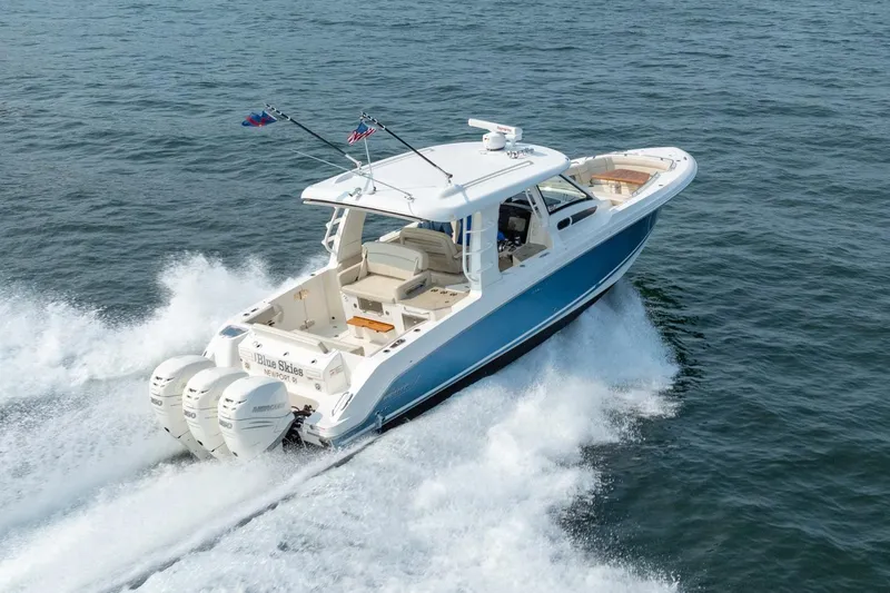 Blue Skies Yacht Photos Pics 2019 Boston Whaler 350 EX REALM cruising on open water, showcasing powerful engines.
