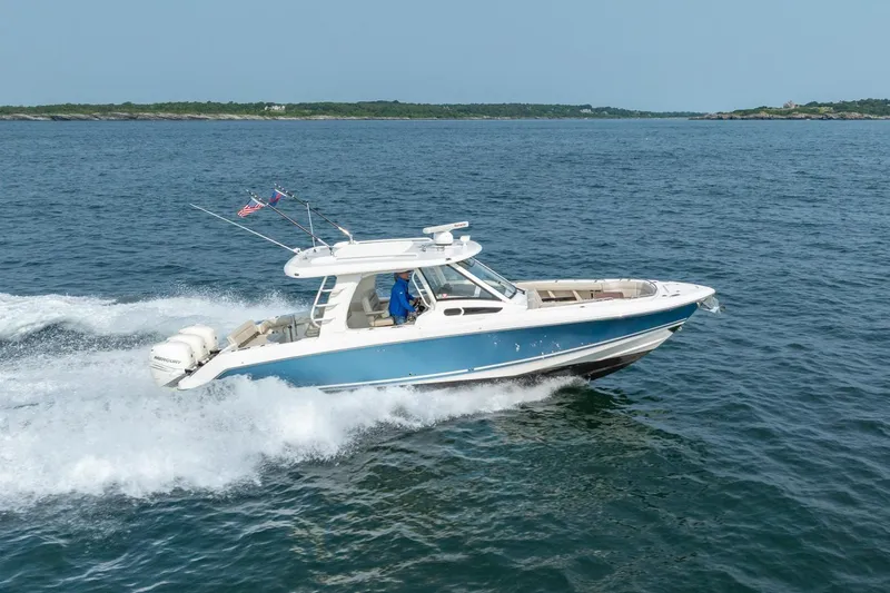 Blue Skies Yacht Photos Pics 2019 Boston Whaler 350 EX REALM cruising on open water, showcasing sleek design and performance.