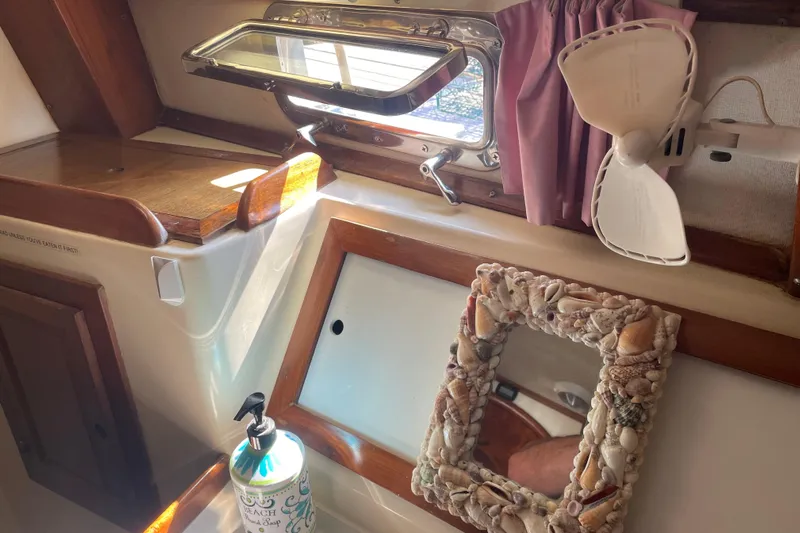 Sun Dazzler Yacht Photos Pics Interior of a 1981 Mariner 48 boat with a seashell mirror and fan.