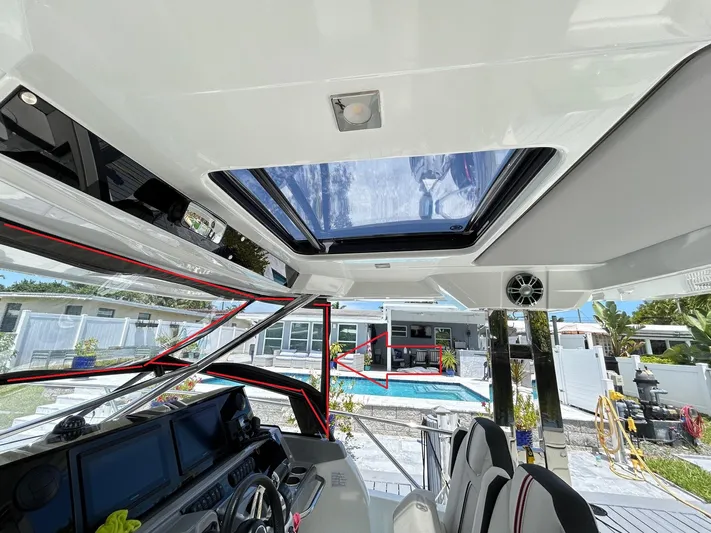 Rosie 3 Yacht Photos Pics Interior view of 2022 Jeanneau Leader 10.5 WA Series 2 boat with skylight and poolside background.