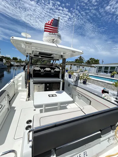 Rosie 3 Yacht Photos Pics 2022 Jeanneau Leader 10.5 WA Series 2 boat with seating and table, docked under blue sky.