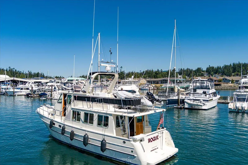 Rogue Yacht Photos Pics 2007 North Pacific NP42 Pilothouse yacht docked in a marina under clear blue skies.