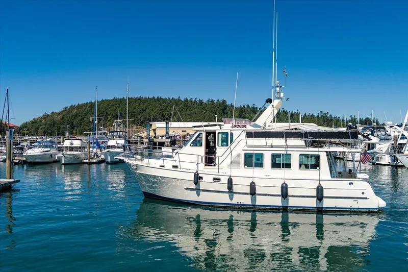 Rogue Yacht Photos Pics 2007 North Pacific NP42 Pilothouse yacht docked in a marina under clear blue skies.