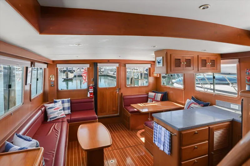 Rogue Yacht Photos Pics Interior of 2007 North Pacific NP42 Pilothouse with wood finish and seating area.