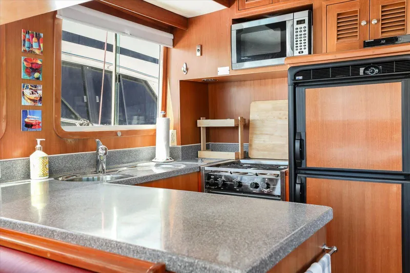 Rogue Yacht Photos Pics 2007 North Pacific NP42 Pilothouse kitchen with modern appliances and wood cabinetry.