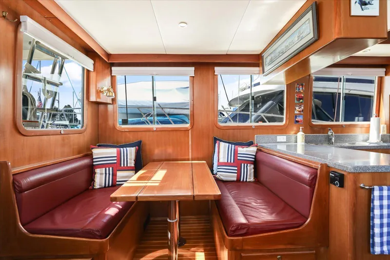 Rogue Yacht Photos Pics 2007 North Pacific NP42 Pilothouse interior with wood finish, red seating, and nautical decor.