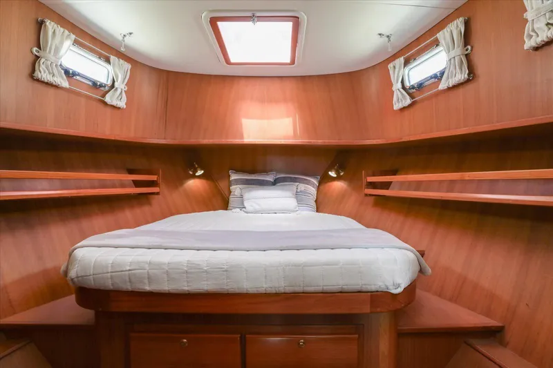 Rogue Yacht Photos Pics Luxurious cabin interior of 2007 North Pacific NP42 Pilothouse with cozy bed and wooden finish.