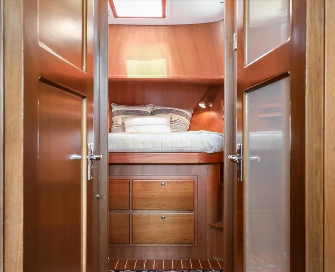 Rogue Yacht Photos Pics Cozy cabin interior of 2007 North Pacific NP42 Pilothouse with wooden finish and bed.