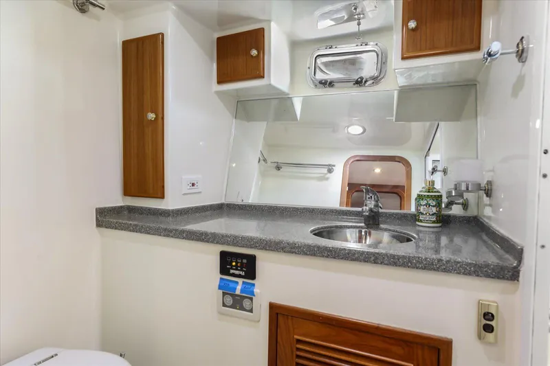 Rogue Yacht Photos Pics Bathroom interior of 2007 North Pacific NP42 Pilothouse with sink, mirror, and wooden cabinets.