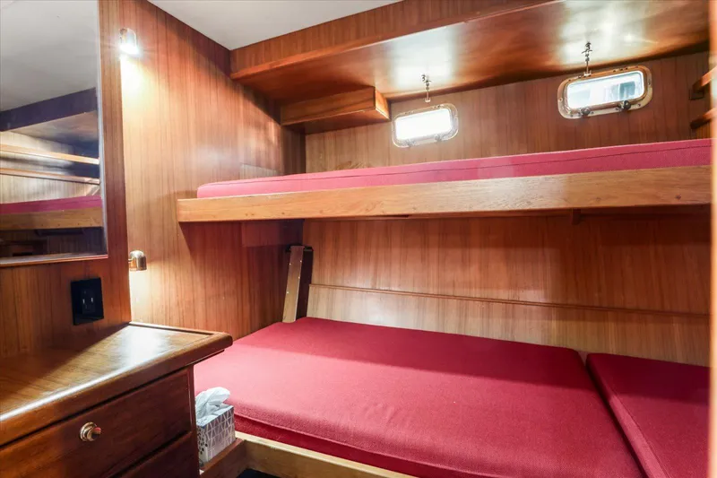 Rogue Yacht Photos Pics Interior of 2007 North Pacific NP42 Pilothouse with wooden bunk beds and red cushions.