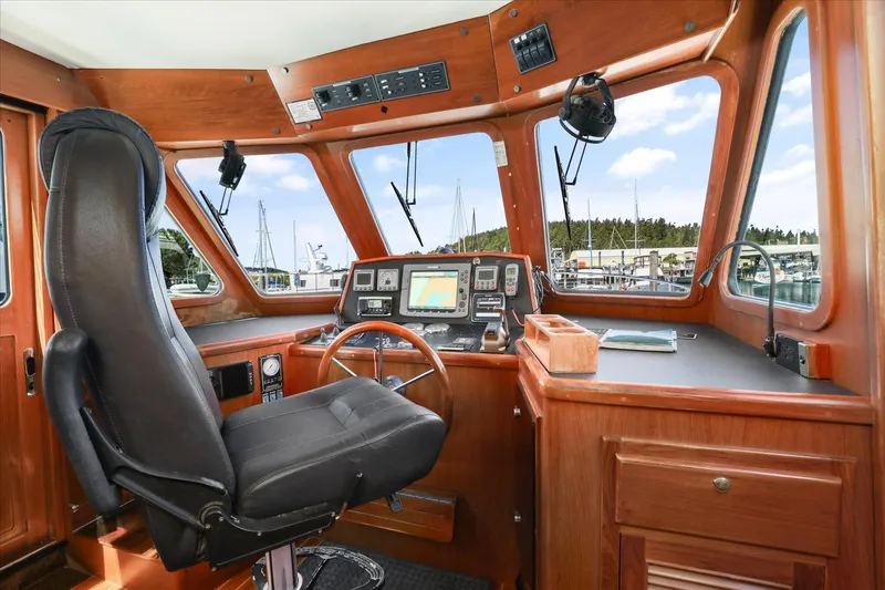 Rogue Yacht Photos Pics Pilothouse interior of 2007 North Pacific NP42, featuring navigation equipment and leather captain's chair.
