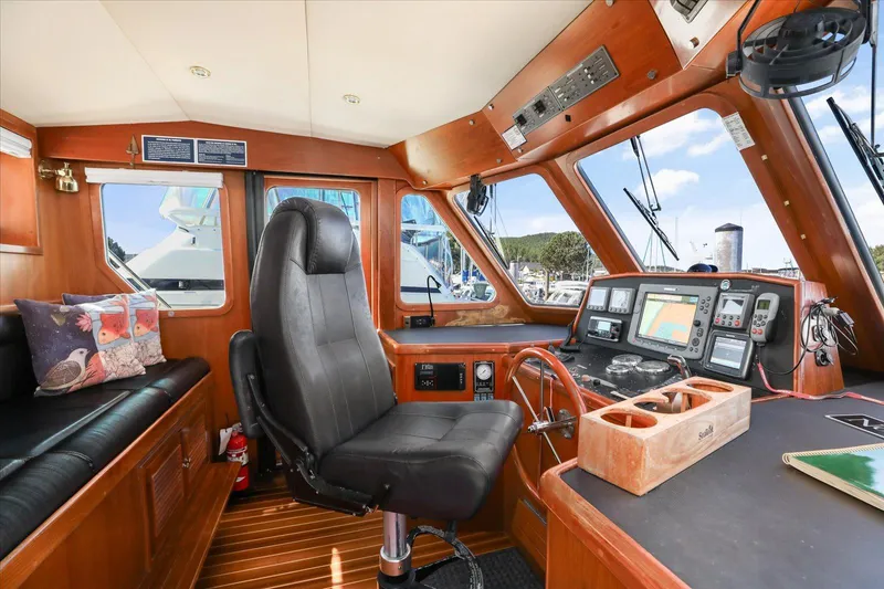 Rogue Yacht Photos Pics Pilothouse interior of 2007 North Pacific NP42, featuring navigation equipment and comfortable seating.