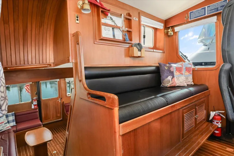 Rogue Yacht Photos Pics 2007 North Pacific NP42 Pilothouse interior with wooden finish and cozy seating area.