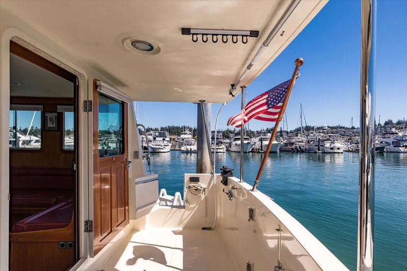 Rogue Yacht Photos Pics 2007 North Pacific NP42 Pilothouse yacht docked, featuring American flag and marina view.