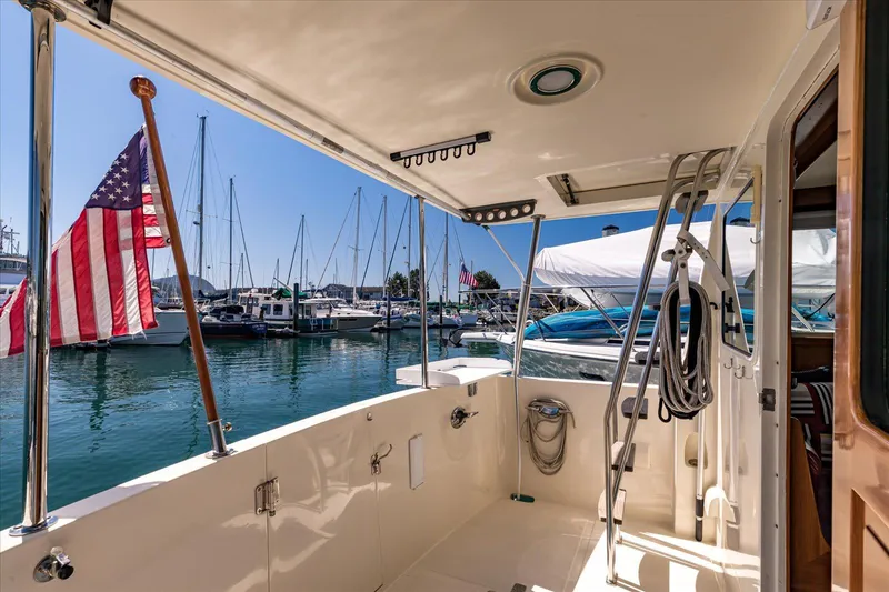 Rogue Yacht Photos Pics 2007 North Pacific NP42 Pilothouse yacht docked, featuring American flag and marina view.