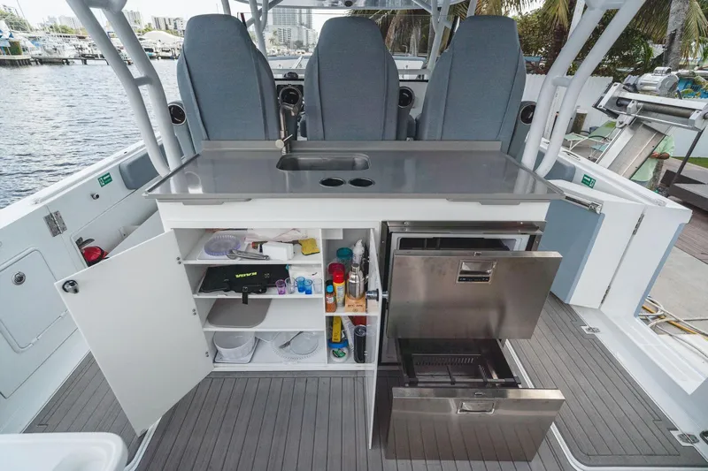  Yacht Photos Pics 2024 YachtCat 41 interior with open storage, stainless steel appliances, and seating by the water.