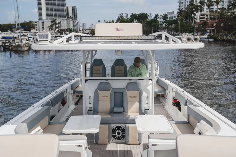  Yacht Photos Pics 2024 YachtCat 41 on water, featuring spacious deck and seating, with cityscape in background.