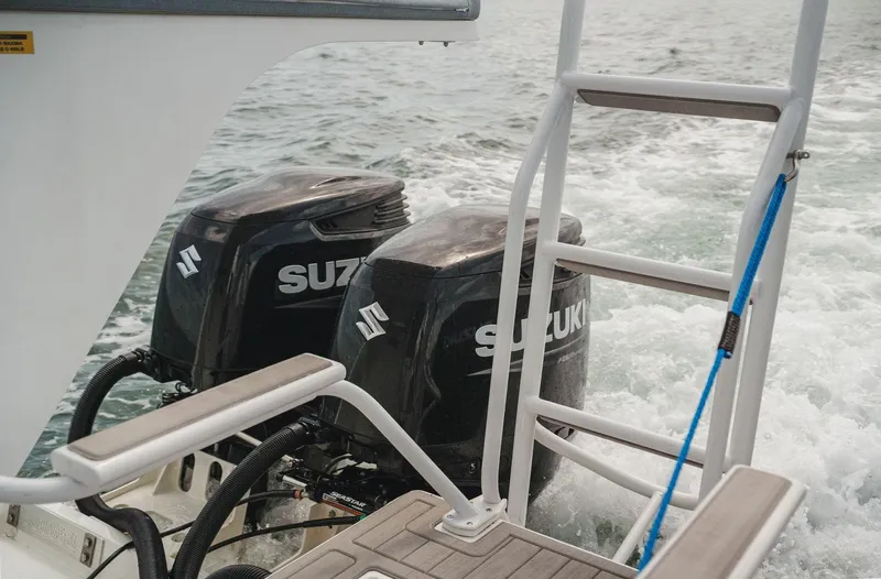  Yacht Photos Pics Twin Suzuki outboard engines on 2024 YachtCat 41, with ladder and ocean backdrop.