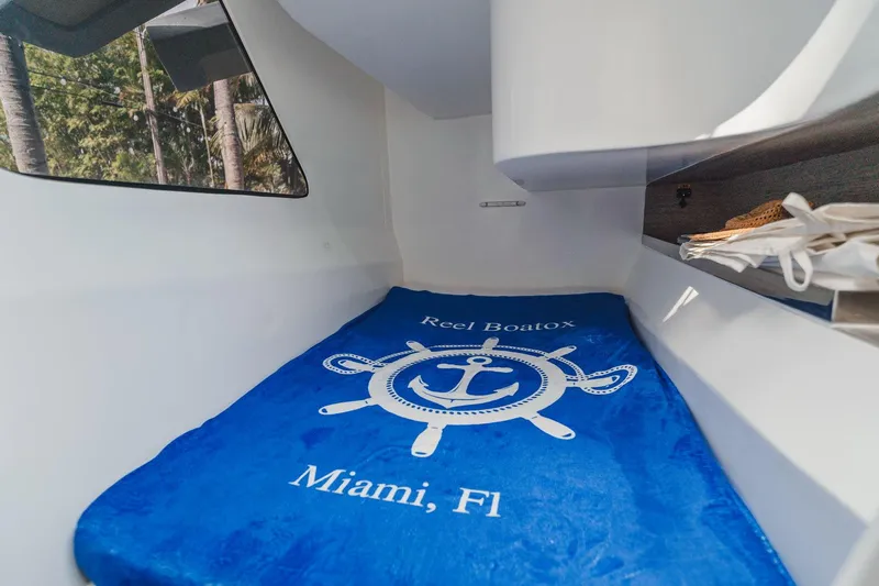  Yacht Photos Pics Cozy cabin interior of 2024 YachtCat 41 with blue nautical-themed bedding.