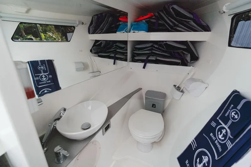  Yacht Photos Pics Modern YachtCat 41 bathroom with sink, toilet, and nautical-themed towels, 2024 model.