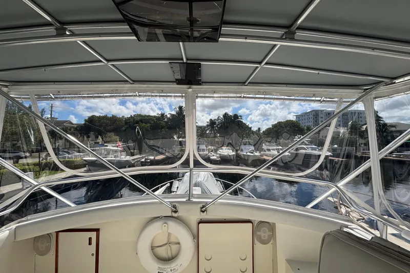 Wonderer Yacht Photos Pics 1987 Bertram 54 Convertible yacht interior view at marina, showcasing helm and surrounding boats.