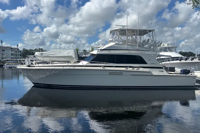 Wonderer Yacht Photos Pics 1987 Bertram 54 Convertible yacht docked on a sunny day with cloudy sky.