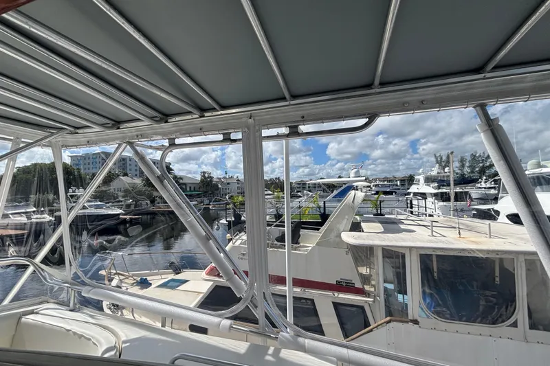 Wonderer Yacht Photos Pics 1987 Bertram 54 Convertible yacht docked at a marina with other boats.