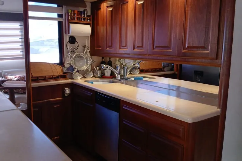 Paloma Yacht Photos Pics Luxurious kitchen interior of a 1991 Viking 57 Convertible yacht with wooden cabinetry.