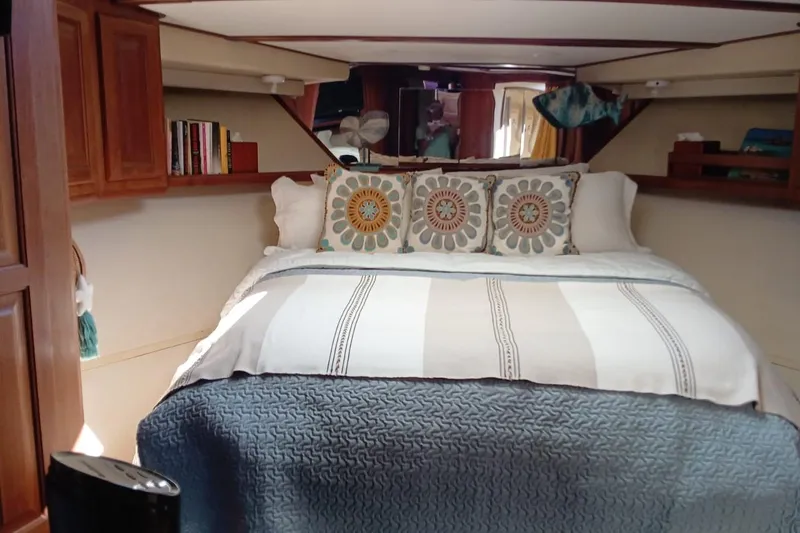 Paloma Yacht Photos Pics Cozy bedroom interior of 1991 Viking 57 Convertible yacht with decorative pillows and wooden cabinets.