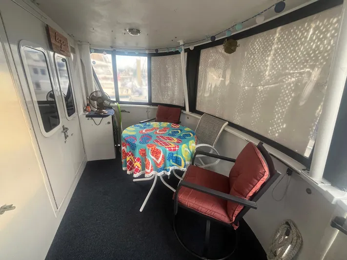 Bazan Yacht Photos Pics Enclosed deck area of 2001 Great Harbour GH47 with colorful tablecloth and seating.