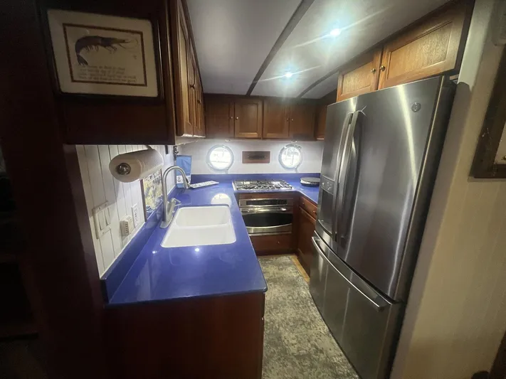 Bazan Yacht Photos Pics Modern kitchen in 2001 Great Harbour GH47 yacht with blue countertops and stainless steel appliances.