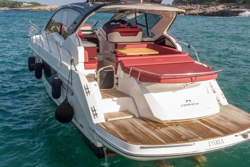  Yacht Photos Pics 2022 Cranchi M44HT yacht with red seating, cruising in clear blue waters.