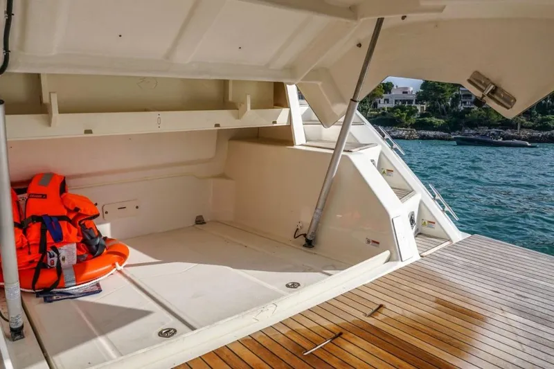  Yacht Photos Pics 2022 Cranchi M44HT yacht storage area with life jackets and lifebuoy, docked by the sea.