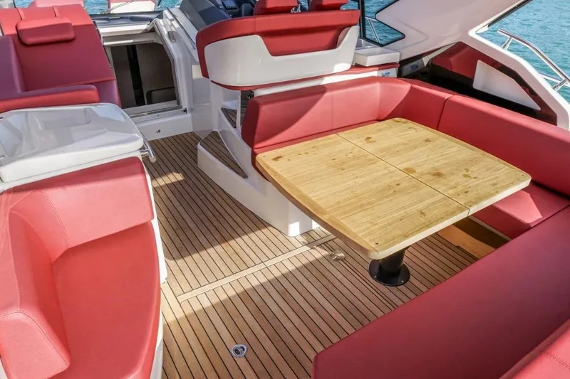  Yacht Photos Pics 2022 Cranchi M44HT yacht interior with red seating and wooden table.